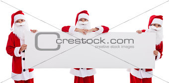 Happy santas holding blank banner