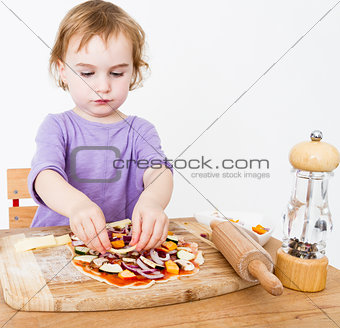 little girl making fresh pizza