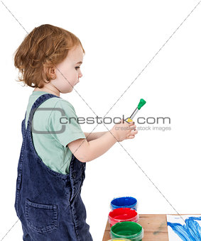 child with brush and green paint