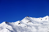 Off-piste slope and blue clear sky in nice winter day