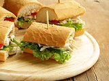 panini sandwich with chicken and vegetables on a wooden board