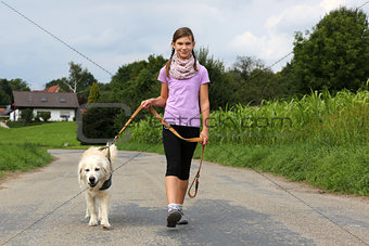 Girl taking a dog for a walk