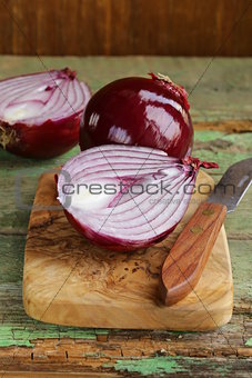 sweet red onions on a wooden chopping board