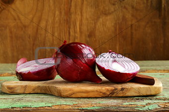 sweet red onions on a wooden chopping board