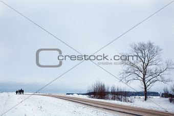 Winter landscape with tree, road and silhouettes