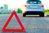 warning triangle on the road and the car moved down to the curb
