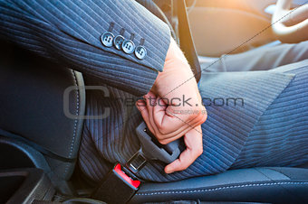 Driver in business suit fastens his seat himself automobile seat belt