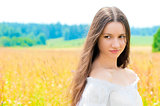 beautiful young Russian girl in a field with gold ears of wheat