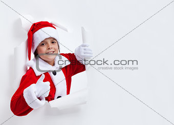 Happy santa costume boy leaning through paper hole - giving thum