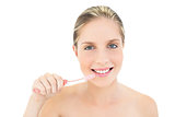 Amused fresh blonde woman brushing her teeth