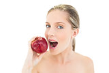 Cute fresh blonde woman eating a red apple