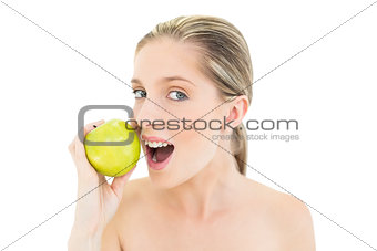 Lovely fresh blonde woman eating a green apple