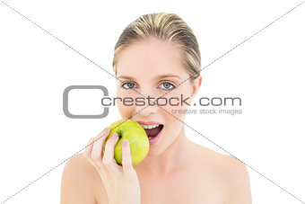 Natural fresh blonde woman eating a green apple
