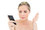 Puzzled fresh blonde woman looking at her mobile phone