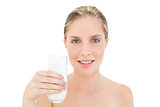 Peaceful fresh blonde woman holding a glass of milk