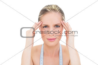 Frowning fresh blonde woman suffering from headache