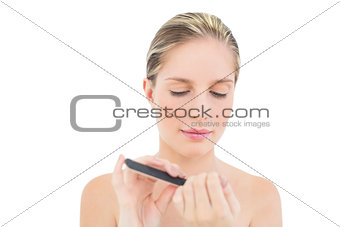 Serious fresh blonde woman filing her nails