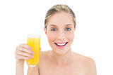 Charming fresh blonde woman holding a glass of orange juice