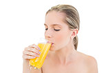 Meditative fresh blonde woman enjoying orange juice