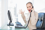 Furious blonde businesswoman screaming on the phone