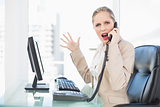 Angry blonde businesswoman screaming on the phone
