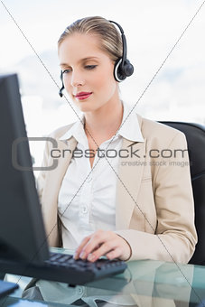 Peaceful blonde call centre agent working on computer