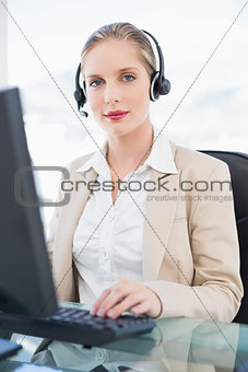 Content blonde call centre agent working on computer
