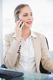 Smiling blonde businesswoman having a phone call posing