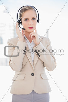 Thoughtful blonde call centre agent standing