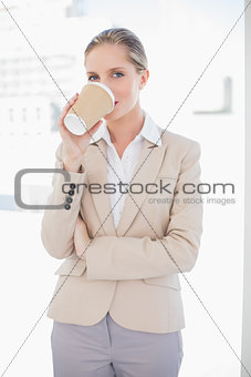 Smiling blonde businesswoman drinking coffee