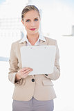 Smiling blonde businesswoman holding clipboard