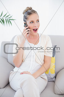 Surprised fresh model in white clothes having a call