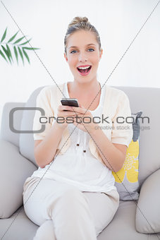 Cheerful fresh model in white clothes texting