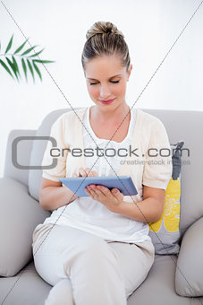 Peaceful fresh model in white clothes using tablet