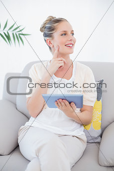 Cheerful fresh model in white clothes using tablet pc