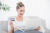 Smiling fresh model shopping online using laptop