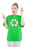 Surprised environmental activist wearing recycling tshirt holding light bulb