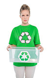 Frowning environmental activist holding empty recycling box