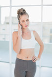 Thoughtful sporty blonde on the phone