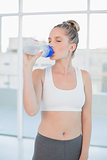 Peaceful sporty blonde drinking water after exercising