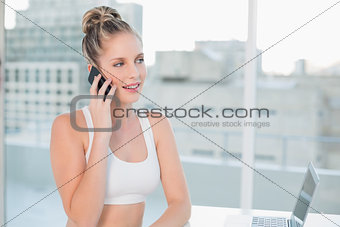 Pensive sporty blonde on the phone