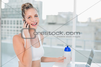 Laughing sporty blonde on the phone