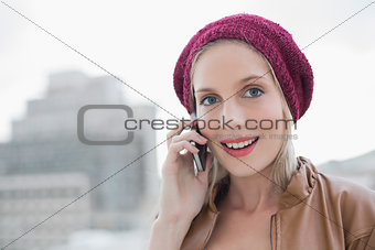Surprised casual blonde on the phone outdoors