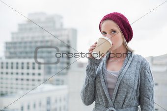 Relaxed casual blonde drinking coffee outdoors