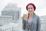 Cheerful casual blonde holding coffee outdoors