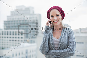 Smiling pretty blonde on the phone outdoors