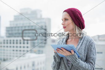 Thinking pretty blonde using tablet pc outdoors