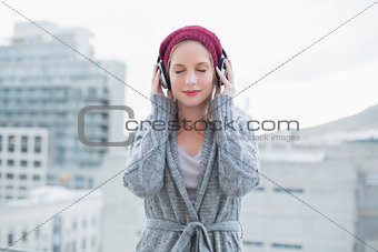 Peaceful pretty blonde listening to music outdoors