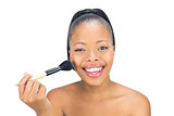 Attractive woman applying powder to face with brush