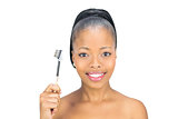 Attractive woman holding eyebrow brush and looking at camera